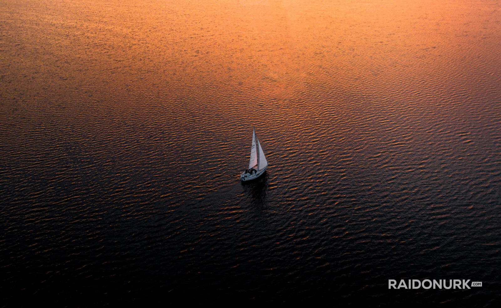 sailor sailing towards the sunset