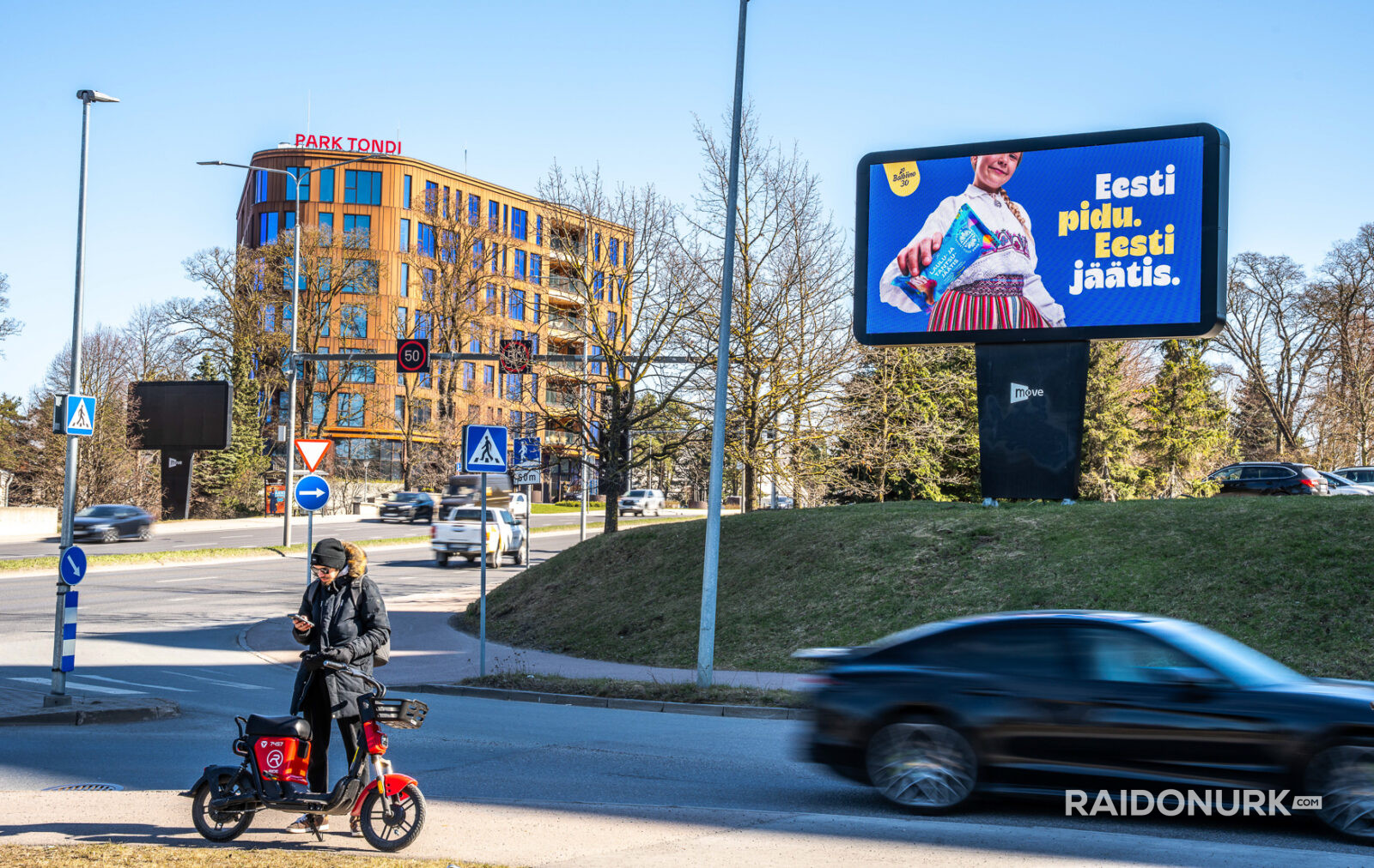 Välimeedia reklaamikampaaniad Tallinna tänavatel, suured digitaalekraanid ja plakatid linnaliikluse taustal.