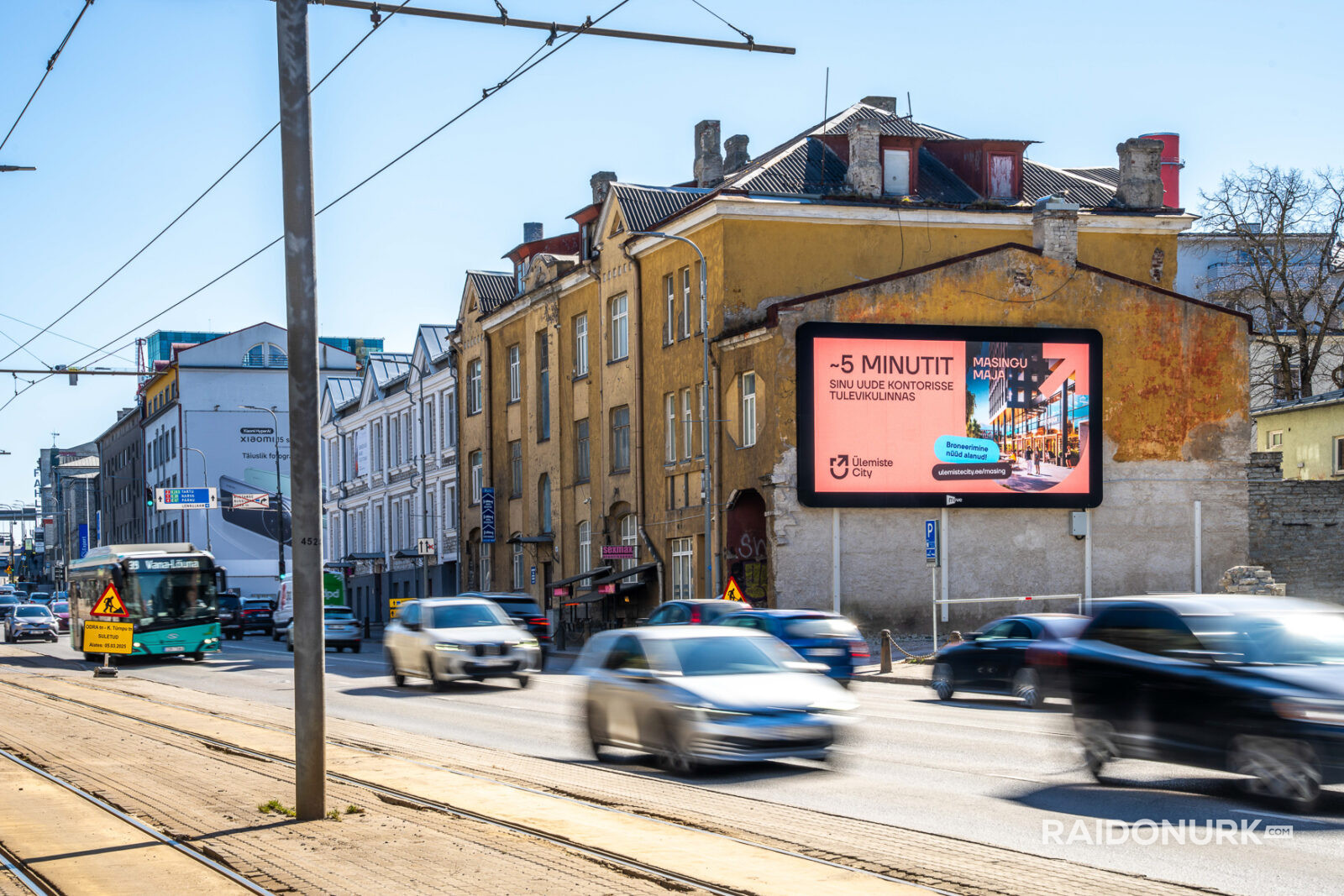 Välimeedia reklaamikampaaniad Tallinna tänavatel, suured digitaalekraanid ja plakatid linnaliikluse taustal.