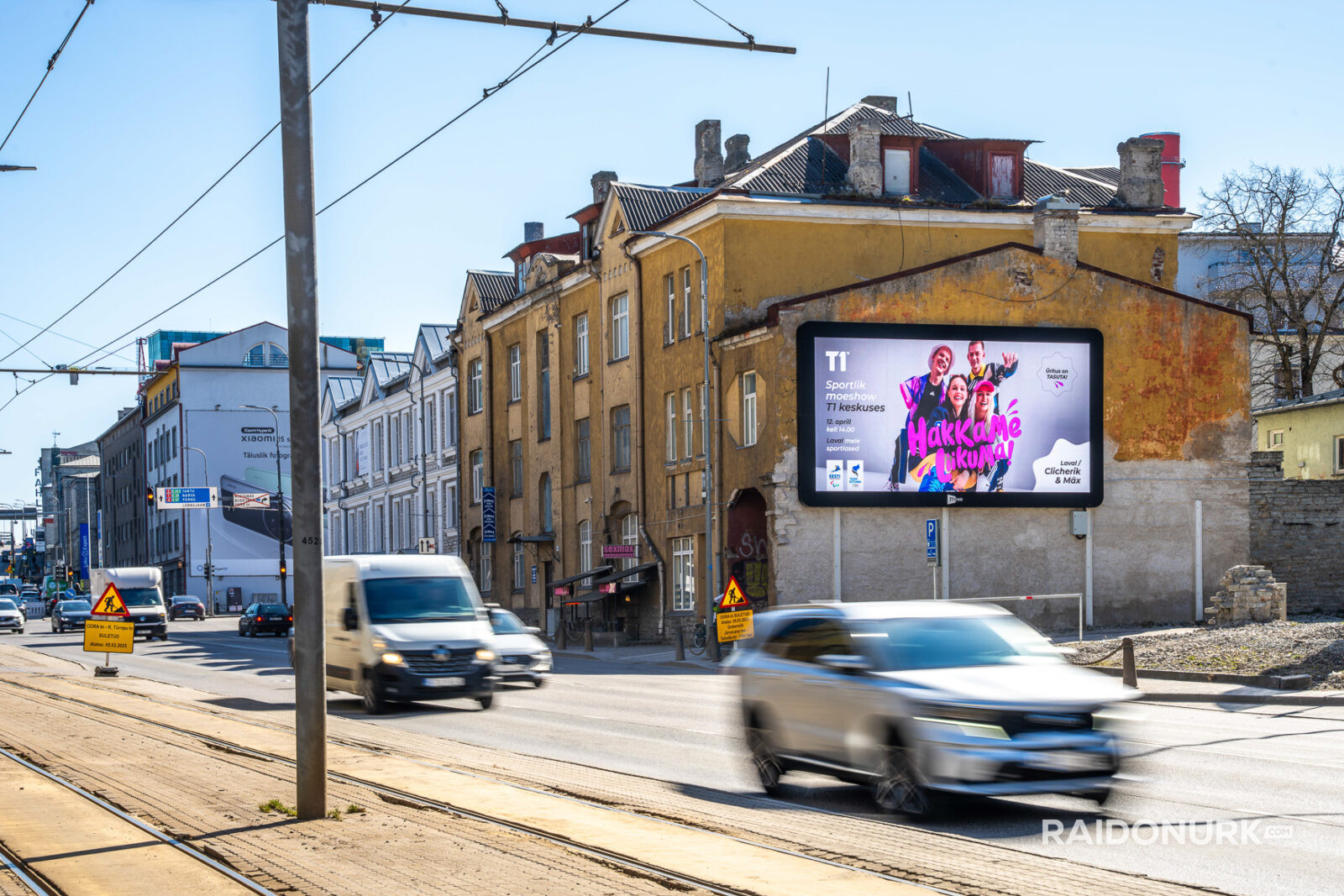 Välimeedia reklaamikampaaniad Tallinna tänavatel, suured digitaalekraanid ja plakatid linnaliikluse taustal.