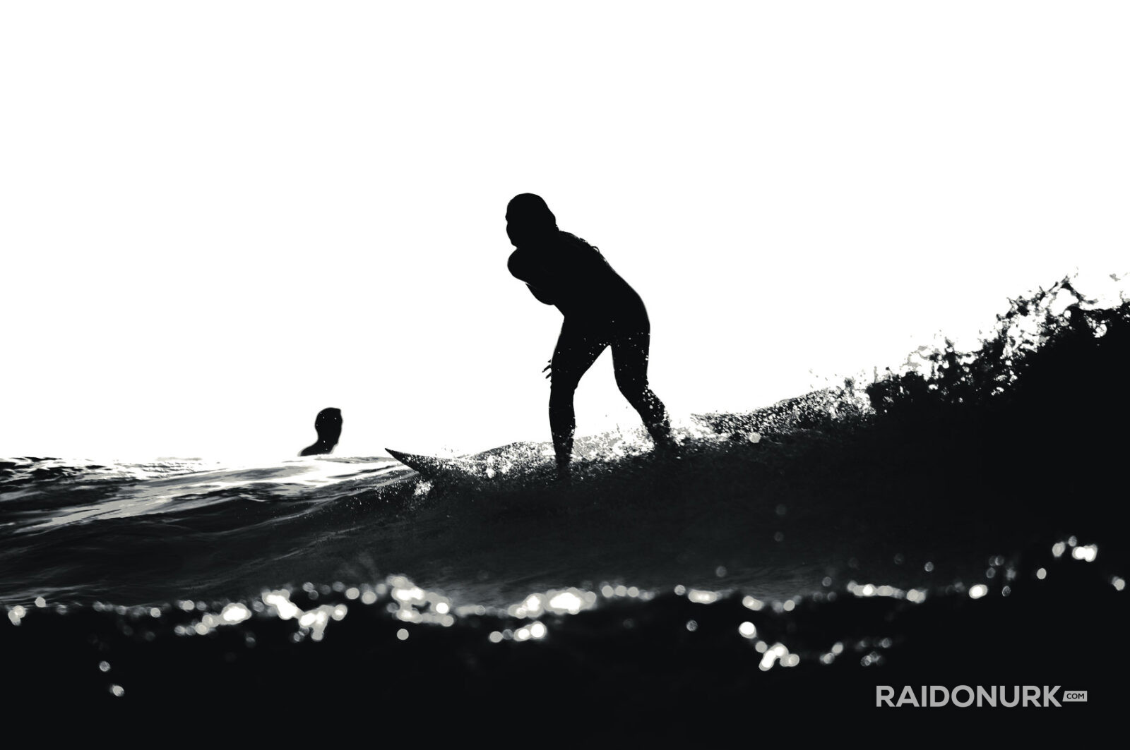 Black and white fine art photographs of surfers in action and at rest, silhouetted against bright skies and dramatic waves, capturing the essence of surfing in a minimalist, high-contrast visual style.