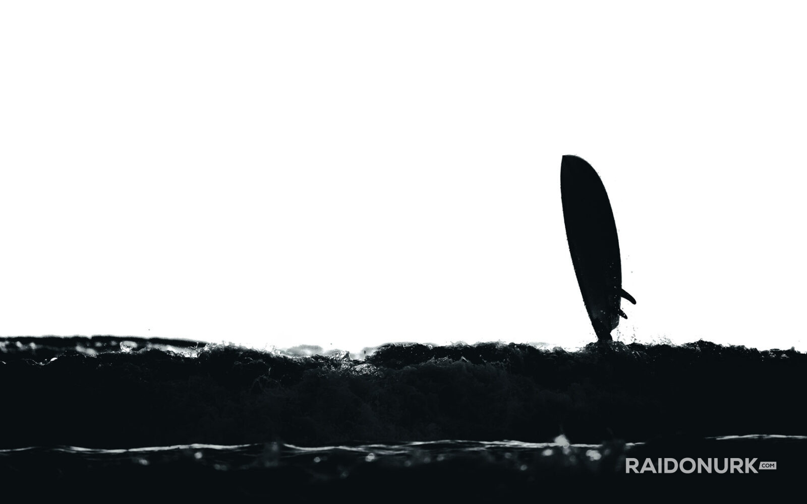 Black and white fine art photographs of surfers in action and at rest, silhouetted against bright skies and dramatic waves, capturing the essence of surfing in a minimalist, high-contrast visual style.