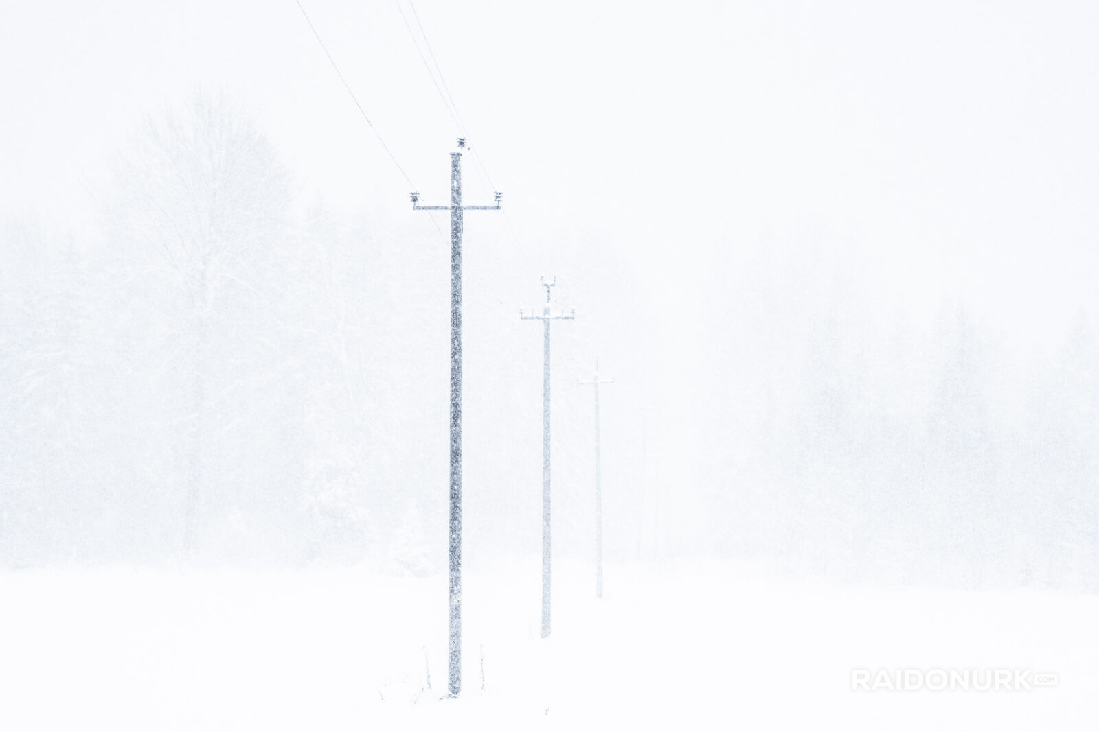 Minimal winter landscape with snowstorm and fading power lines
